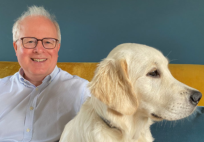 a photo of partner Adrian Budgen sat with his golden retriever